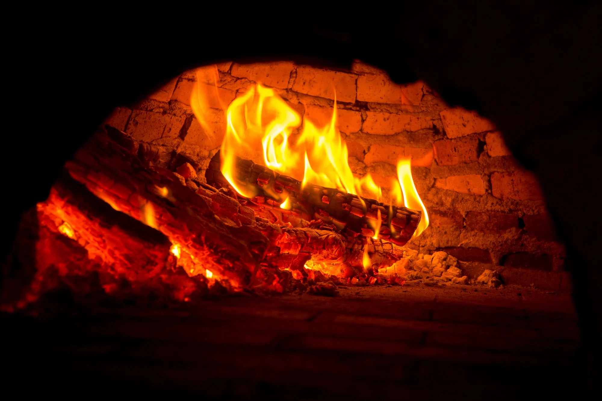 Burning logs inside a brick-lined firebox