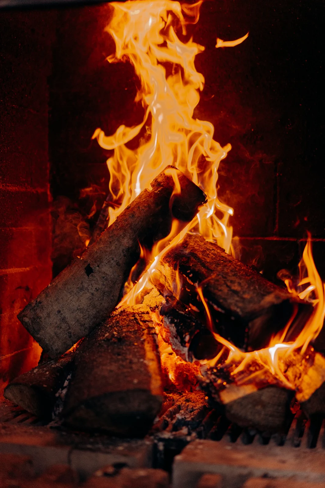 Tall flames above logs within a fireplace